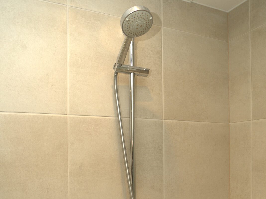Hand shower on a slide rail in a tiled shower by JT Handyman Solutionz