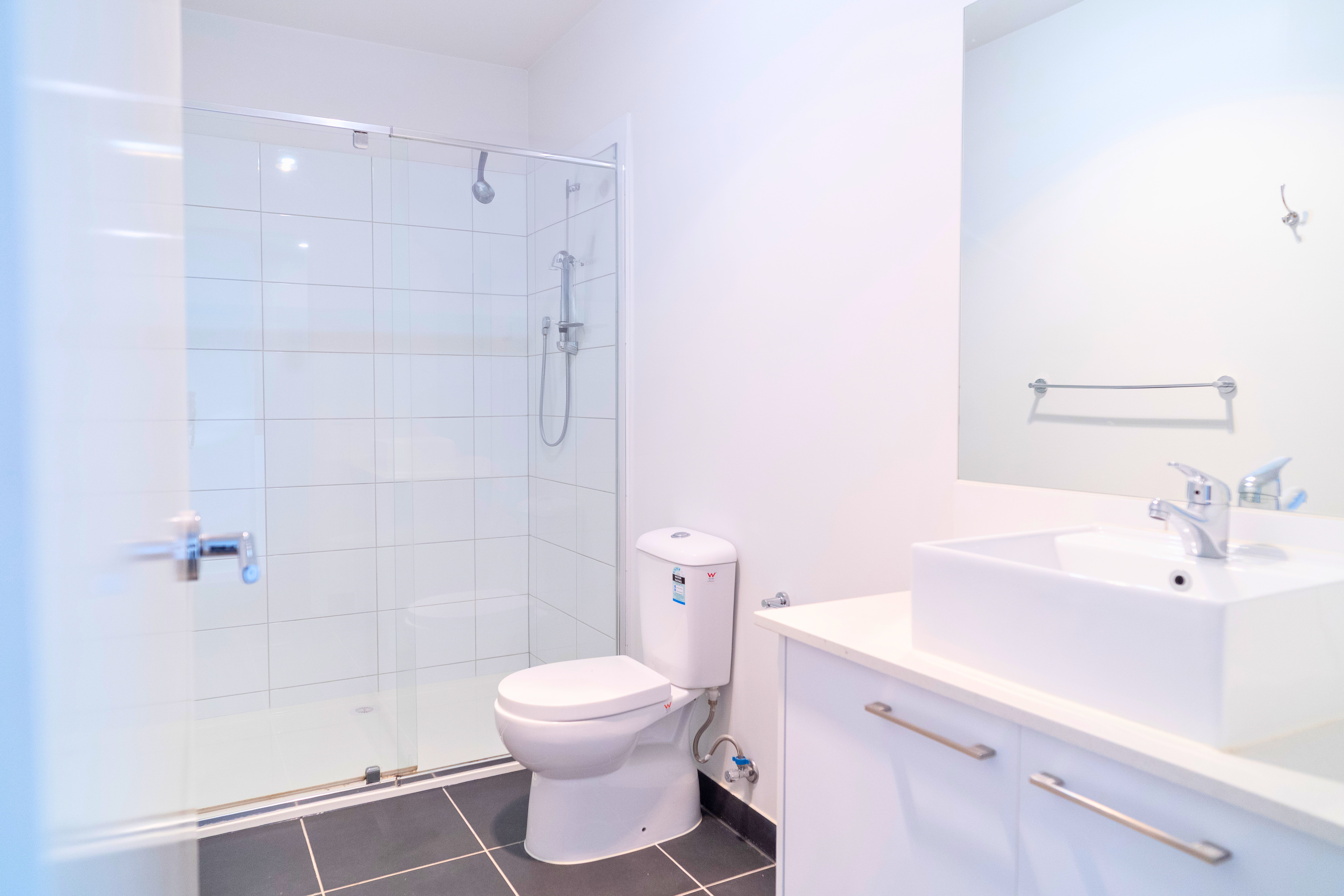 Newly tiled bathroom with a modern shower installed by JT Handyman Solutionz